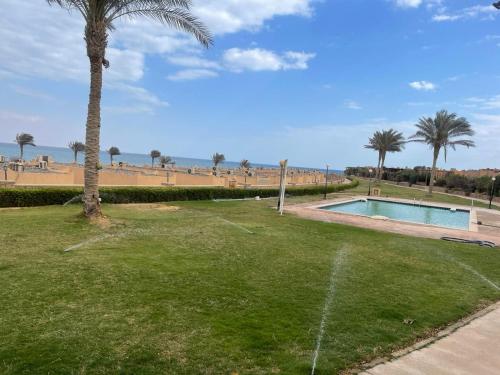 een park met een zwembad en palmbomen bij فيلا شيري in Ain Sokhna