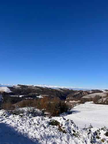 a snow covered hill with a view of a valley at Nina s Casa di Langa in Rocca Ciglie