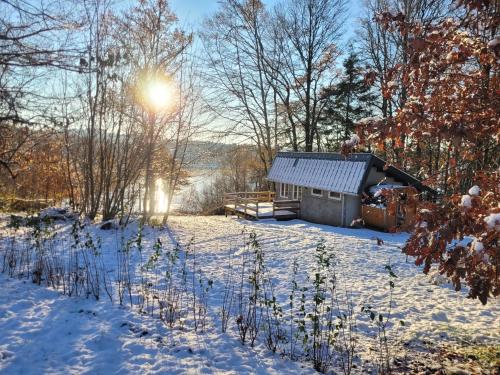 une cabane dans la neige avec le soleil en arrière-plan dans l'établissement Petite maison vue sur Lac de la Triouzoune Neuvic, à Neuvic