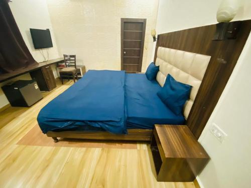 um quarto com uma cama grande com lençóis azuis em Hotel White affordable Stay - Near Taj em Agra