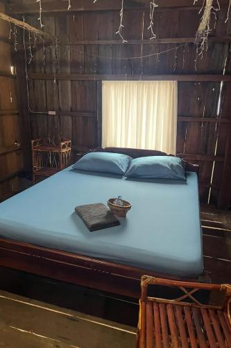 a bed in a wooden room with a bowl on it at Gecko Guesthouse in Koh Rong Island