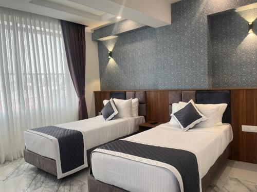 a hotel room with two beds and a window at SABU's GRAND ROYALE HOTEL in Trivandrum