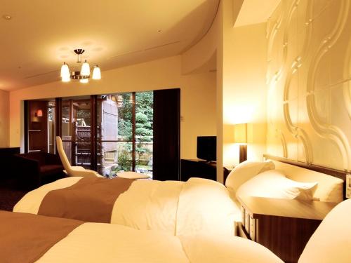 Una habitación de hotel con dos camas y una ventana. en Shoenso Hozugawatei, en Kameoka