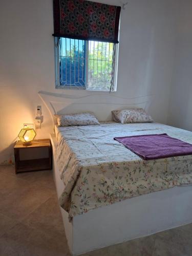 ein Schlafzimmer mit einem großen Bett mit Fenster in der Unterkunft Furali'Sa in Paje