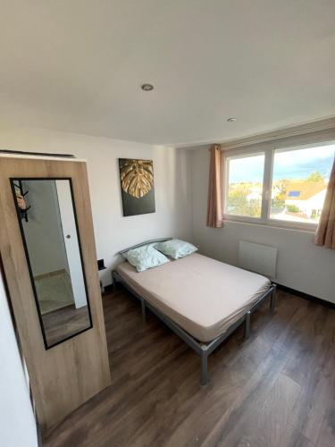 une petite chambre avec un lit et un miroir dans l'établissement Famille LATT, à Ouges