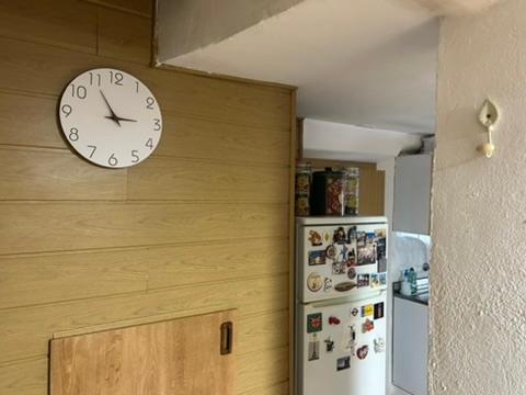 a clock on a wall next to a refrigerator at Casa Rural en BRAÑOSERA in Brañosera