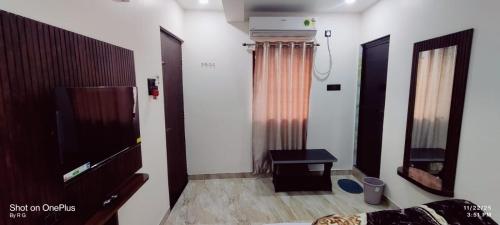 a room with a bed and a television and a table at HOTEL RS Palace in Ghātsīla