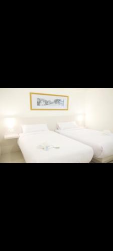 Una fila de lavabos blancos en una habitación. en Easy staycation, en Rampal