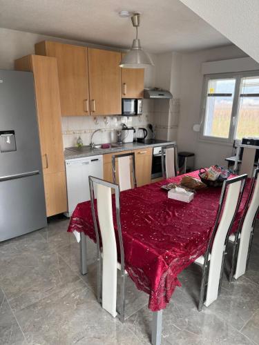 a kitchen with a table with a red table cloth on it at Au petit Logelbach in Wintzenheim