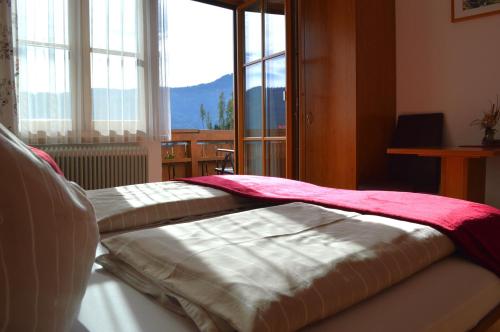 una cama en una habitación con una ventana grande en Bauernhof Bachgut, en Mühlbach am Hochkönig