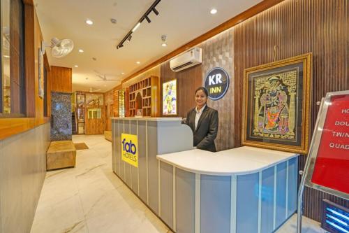 Un hombre de pie en un mostrador en un vestíbulo. en Hotel Rohan Palace, en Vrindāvan