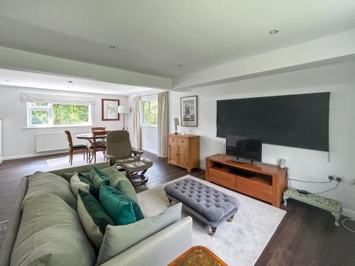 un salon avec un canapé et une télévision à écran plat dans l'établissement Shepherds Loft, à Shermanbury