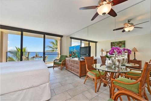 a bedroom with a bed and a table and chairs at Mahana 602 · MA 602 Kaanapali OceanFront Studio Ocean View Pool in Kahana
