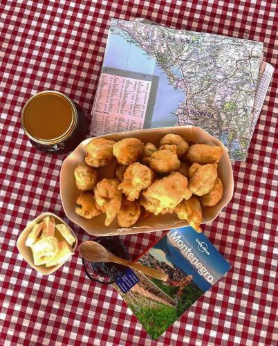 un tazón de comida en una mesa con un libro en Rooms Dujeva Drago-Resort, en Rijeka Crnojevića