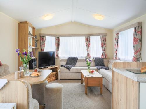 ein Wohnzimmer mit Sofa und Fernseher in der Unterkunft The Villa At Youlditch Farm in Okehampton