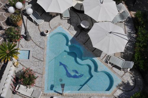 einen Blick über einen Pool mit Sonnenschirmen in der Unterkunft Esedra Hotel in Rimini