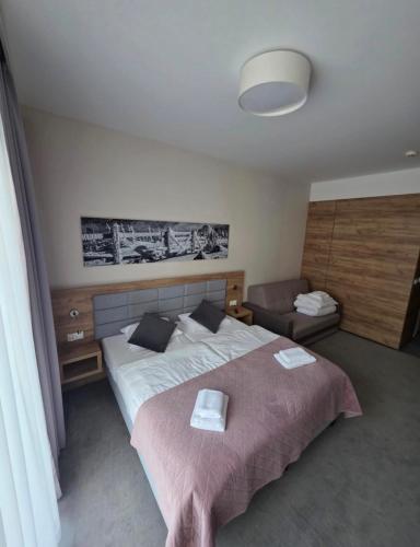 a bedroom with a large bed and a chair at RentResidence apartament in Sienna