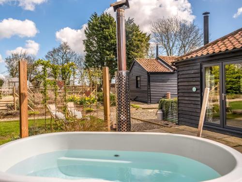 bañera en un patio con patio trasero en The Old Press - Uk50806, en Cratfield
