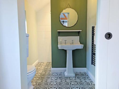 a bathroom with a sink and a mirror at The Cowshed - Uk50803 in Cratfield