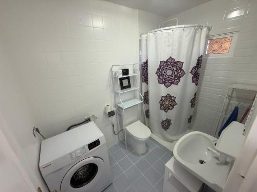 a bathroom with a toilet sink and a washing machine at Studio La Calita in Mijas Costa