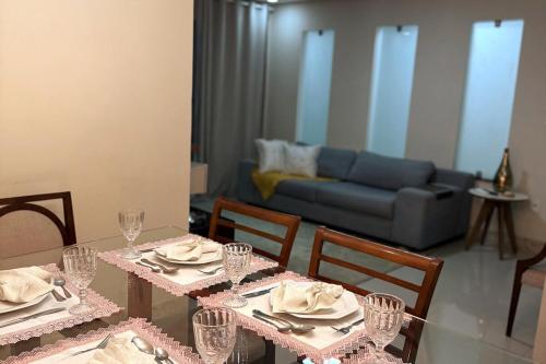 a dining room with a table with chairs and a couch at Casa completa e climatizada em Ilhéus in Ilhéus