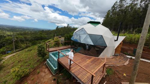 eine Person, die auf einem Deck mit einem Regenschirm steht in der Unterkunft Domo Malacara View in Praia Grande