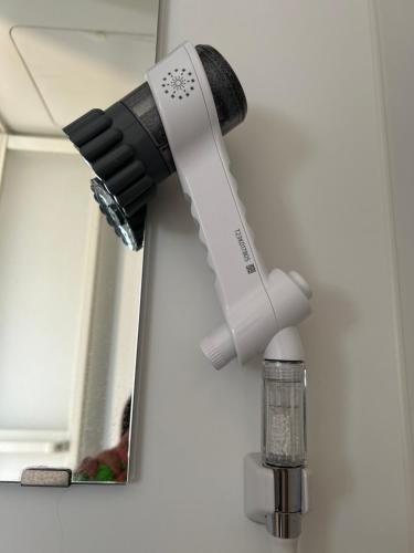 a black and white blow dryer hanging from a mirror at ゲストハウスHayatamaわびさび in Shingū