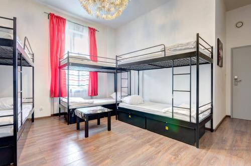 a room with four bunk beds and a chandelier at 3 City Hostel in Gdańsk
