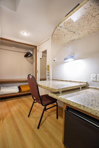 a kitchen with a desk and a chair in a room at Bourbon Londrina Hotel in Londrina