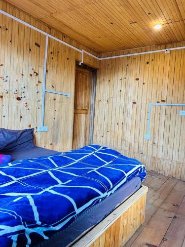a room with a bed in a wooden wall at Meet by cooincidence homestay - A place of peace and nature in Shangarh