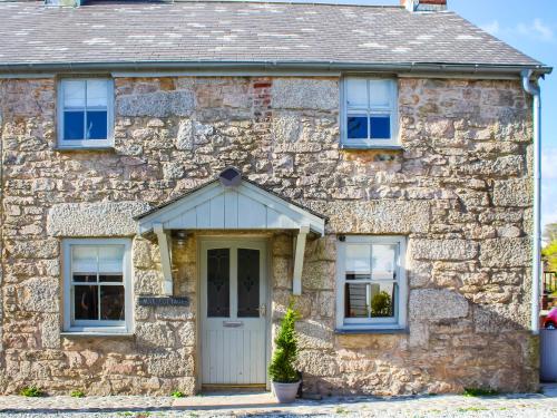 een stenen huis met een witte deur en ramen bij The Cottage - Uk50652 in Stithians