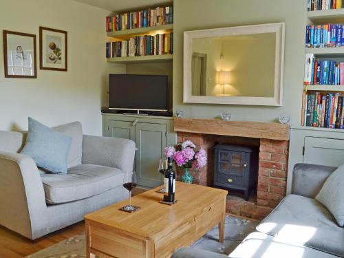 a living room with two couches and a fireplace at Owl Cottage in Fordwich
