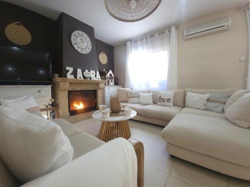 a living room with white furniture and a fireplace at bellazaira in Ruidera