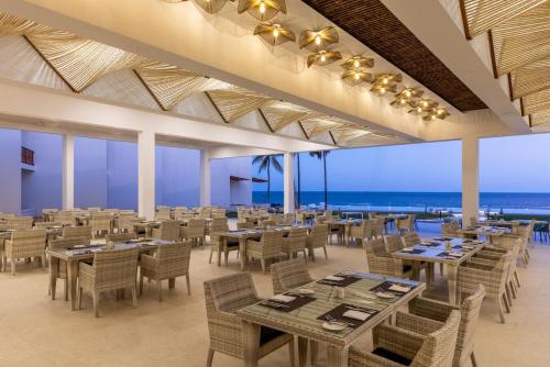 Un restaurante con mesas y sillas y el océano. en Bamburi Beach Hotel, en Bamburi
