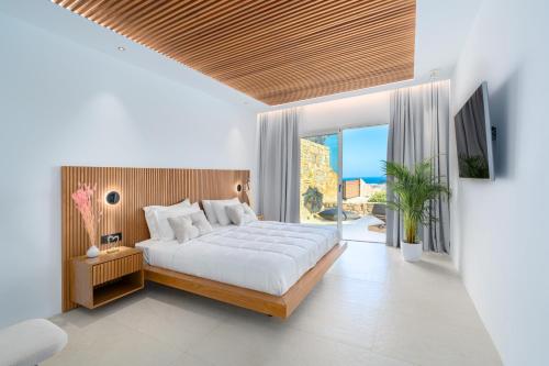 Elit Villa Psarou في بسارو: غرفة نوم بها سرير كبير وتلفزيون