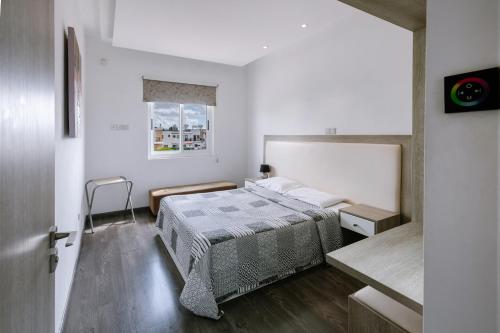 Un dormitorio con una cama y una ventana en Neptune Hotel Apartments Paphos, en Bahía de Coral