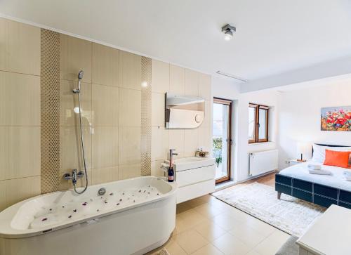 a large bathroom with a tub and a bed at Vila LINA in Braşov