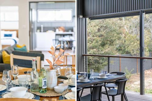 une table de salle à manger avec des bouteilles de vin et des verres dans l'établissement Coastal Retreat, à Kioloa