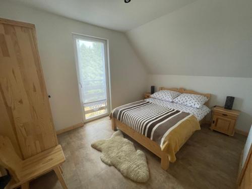 a bedroom with a bed and a window at Domki przy szlaku Szczebel in Lubień