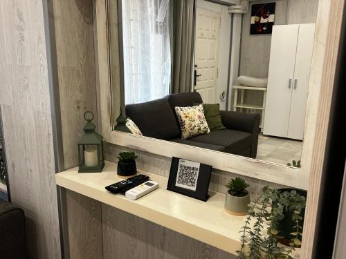sala de estar con espejo y sofá en Beachside Studio Apartment with AC, en Costa de Adeje