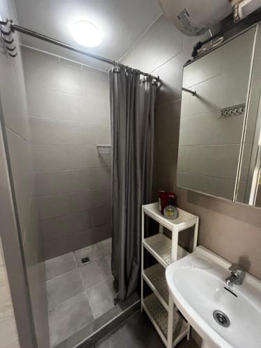 Un baño con ducha, lavabo y espejo. en Beachside Studio Apartment with AC, en Costa de Adeje