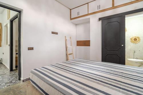 Schlafzimmer mit einem Bett und einer schwarzen Tür in der Unterkunft Villa Marrakech réservée aux familles in Marrakesch