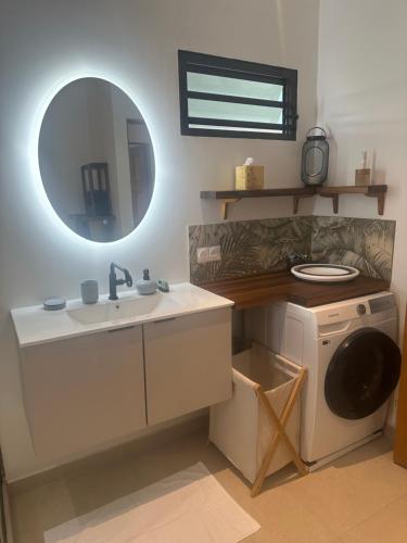 a bathroom with a sink and a washing machine at Nanua Lodge 1 green in Bora Bora