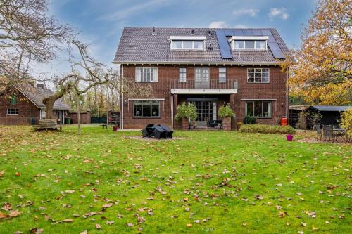 a house with a yard with leaves on the grass at BergOpwaerts in Sint Odiliënberg