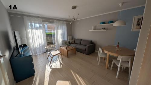ein Wohnzimmer mit Tisch und Couch in der Unterkunft Apartamenty Morze Wygody in Międzywodzie