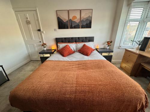 a bedroom with a large bed with two red pillows at Lovely 1-Bed City Centre escape with Kitchen & Free Parking in Spon End