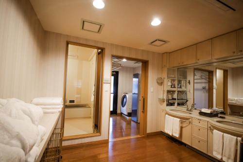 ein Badezimmer mit einem Waschbecken und einer Theke mit Handtüchern in der Unterkunft ザレジデンスホテル岡山 in Okayama