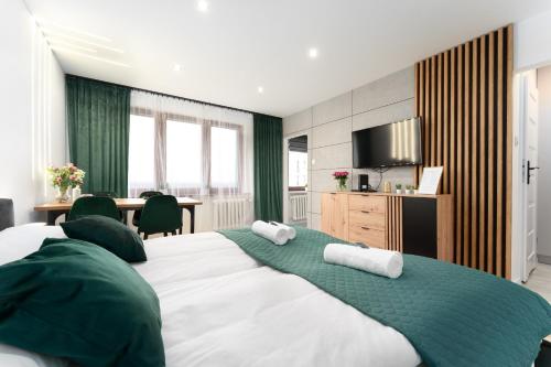 a bedroom with a large bed with towels on it at Modern Home in Sosnowiec