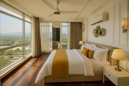 a bedroom with a large bed and a large window at Guest Nest Executive Stay- Elysium Tower Opposite Centaurus Mall Islamabad in Islamabad