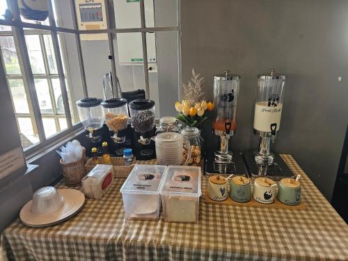 uma mesa com comida e outros itens em cima dela em Mandalar Arch 39 Hotel em Chiang Mai